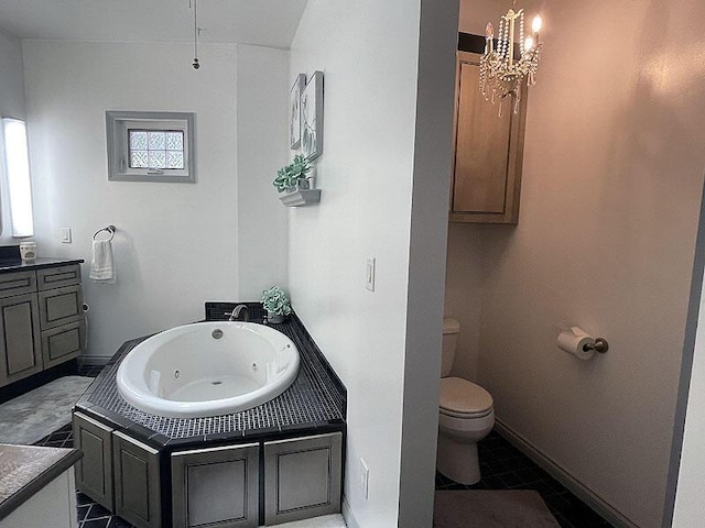 bathroom featuring toilet, baseboards, a jetted tub, and tile patterned floors