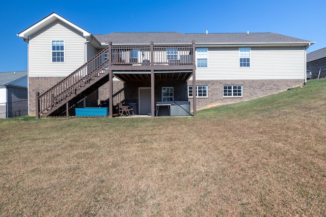 rear view of house with a wooden deck and a lawn