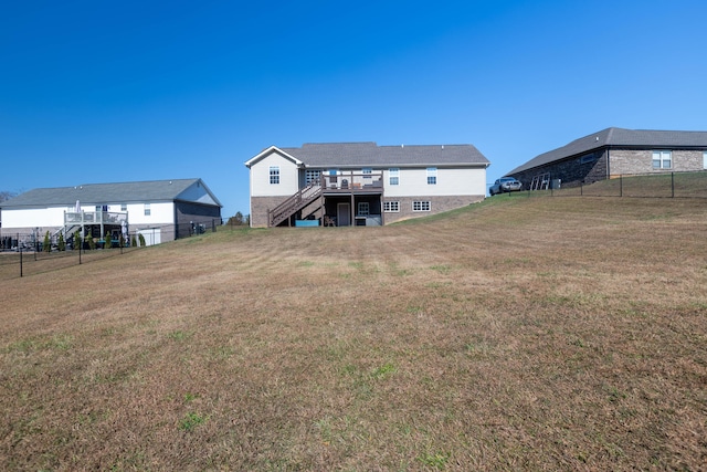 rear view of property featuring a wooden deck and a yard