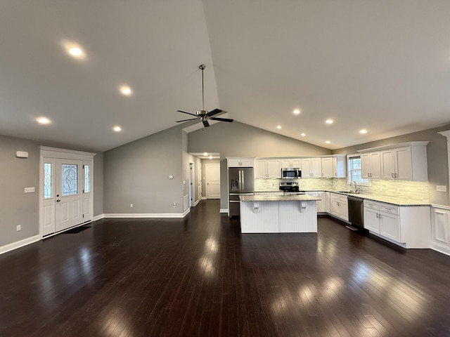 kitchen with white cabinetry, stainless steel appliances, dark hardwood / wood-style floors, and a kitchen island