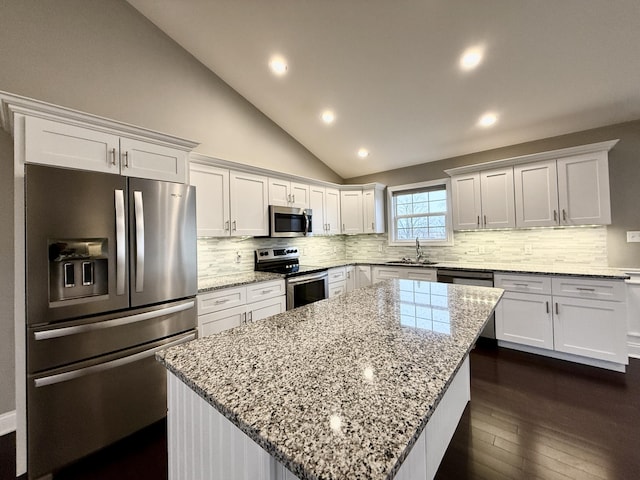 kitchen with white cabinetry, stainless steel appliances, and a kitchen island