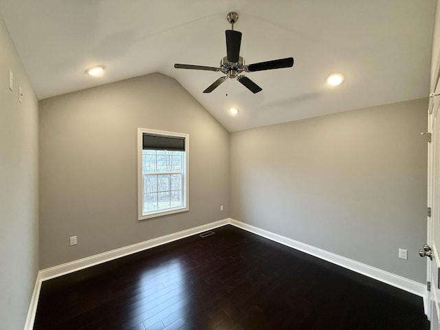 empty room featuring dark hardwood / wood-style flooring, vaulted ceiling, and ceiling fan