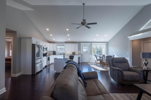 living room featuring ceiling fan, a healthy amount of sunlight, dark hardwood / wood-style flooring, and high vaulted ceiling