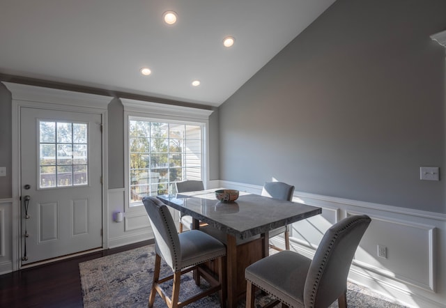 dining area featuring lofted ceiling and dark hardwood / wood-style floors