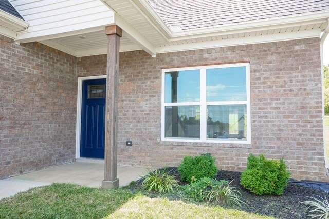 view of exterior entry with a patio area