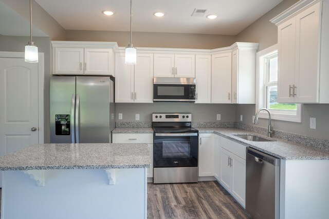 kitchen featuring white cabinetry, appliances with stainless steel finishes, decorative light fixtures, and sink