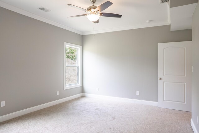 empty room with ornamental molding, carpet floors, and ceiling fan