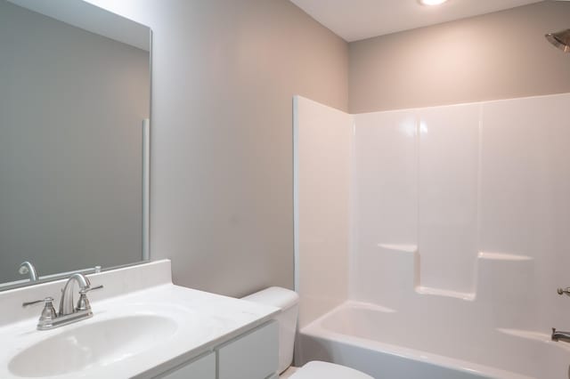 full bathroom featuring vanity, bathing tub / shower combination, and toilet