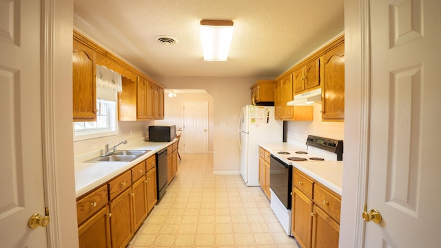 kitchen with sink, a textured ceiling, light tile patterned flooring, and white appliances