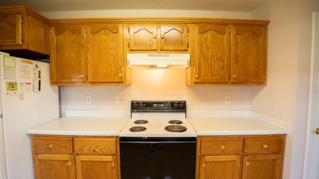 kitchen featuring white electric range oven, refrigerator, and a textured ceiling