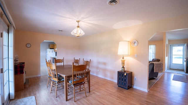 dining room featuring a textured ceiling and wood-type flooring