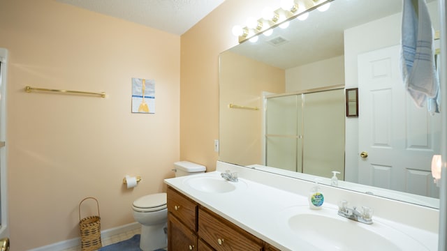 bathroom with double sink vanity, a textured ceiling, tile patterned flooring, and toilet