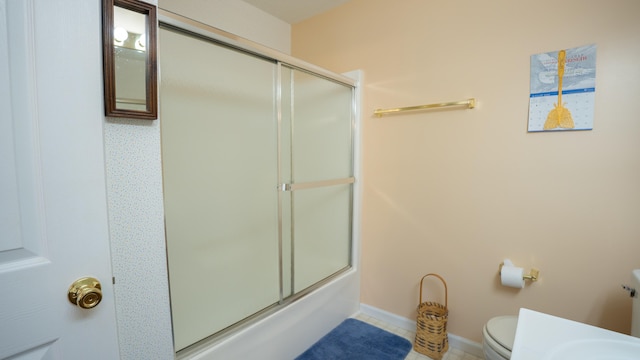 bathroom featuring tile patterned floors, bath / shower combo with glass door, and toilet