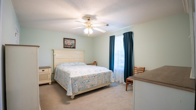 carpeted bedroom featuring a textured ceiling and ceiling fan