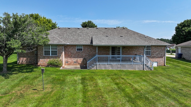 back of property with a deck and a yard