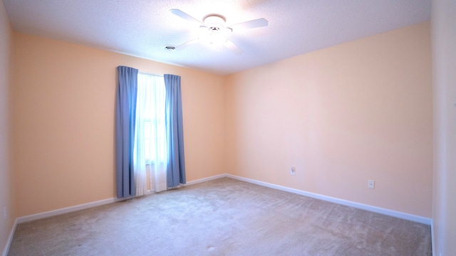 carpeted spare room with a textured ceiling and ceiling fan