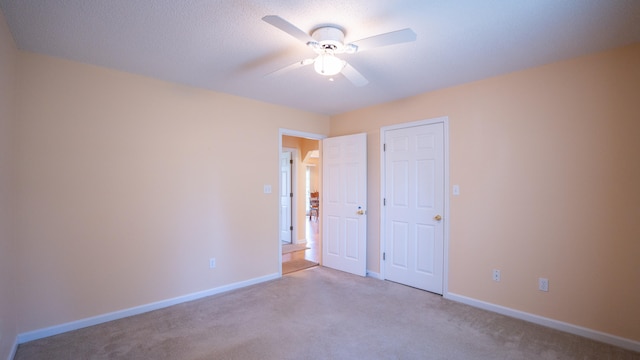 empty room with ceiling fan and light colored carpet