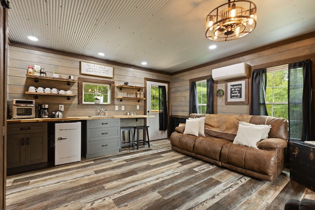 living room featuring light wood-type flooring, sink, wooden walls, and a wall unit AC