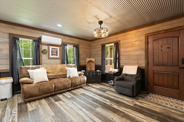 living room with wood walls, hardwood / wood-style floors, a notable chandelier, an AC wall unit, and radiator heating unit