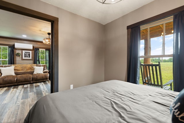 bedroom featuring hardwood / wood-style flooring and a wall mounted AC