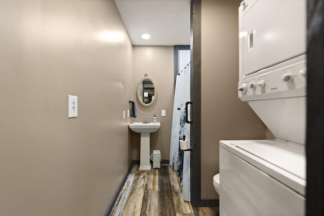 washroom with sink, stacked washer and dryer, and dark hardwood / wood-style floors