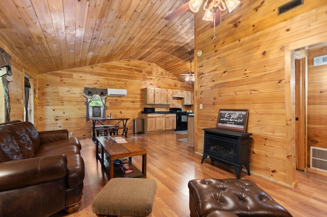 living room with light hardwood / wood-style floors, a wood stove, wooden walls, ceiling fan, and wooden ceiling