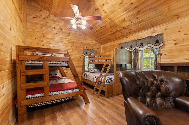 bedroom with light wood-type flooring, vaulted ceiling, wooden ceiling, and wooden walls