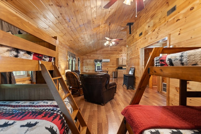 bedroom featuring wooden walls, vaulted ceiling, light hardwood / wood-style floors, and wooden ceiling