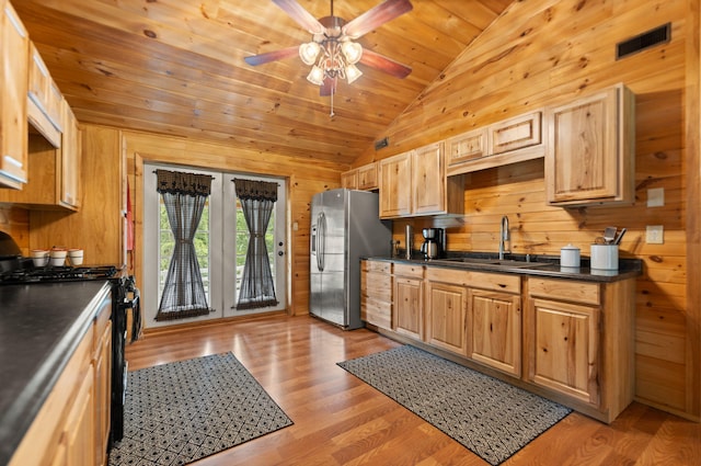 kitchen with light wood-type flooring, vaulted ceiling, appliances with stainless steel finishes, wooden ceiling, and sink