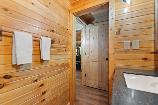 bathroom with wooden ceiling, hardwood / wood-style flooring, wooden walls, and vanity