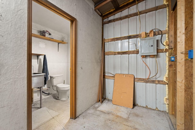 bathroom featuring electric panel and toilet