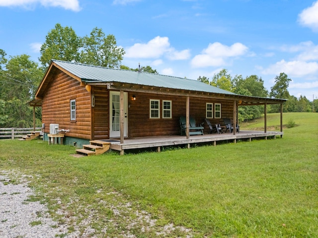 view of front of home with a deck, a front yard, and french doors