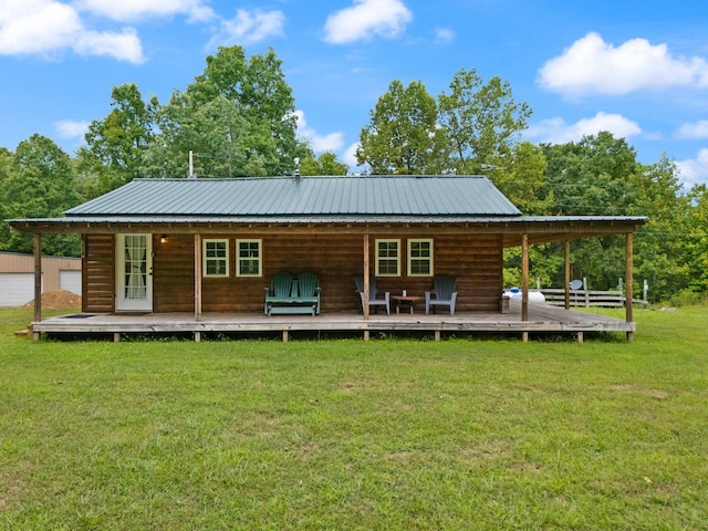 rear view of house with a deck and a yard