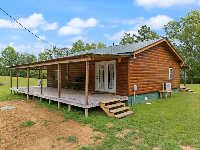 rear view of house featuring central AC unit, a deck, french doors, and a yard