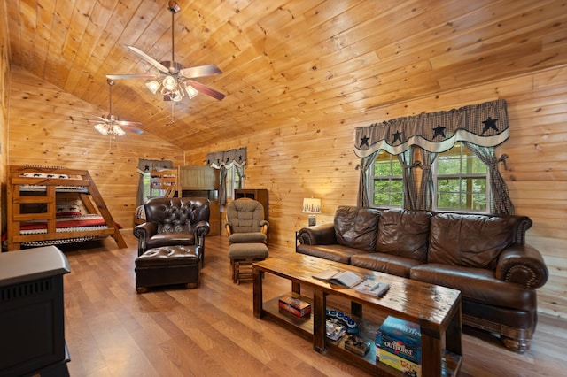 living room with light hardwood / wood-style flooring, vaulted ceiling, wooden walls, wood ceiling, and ceiling fan