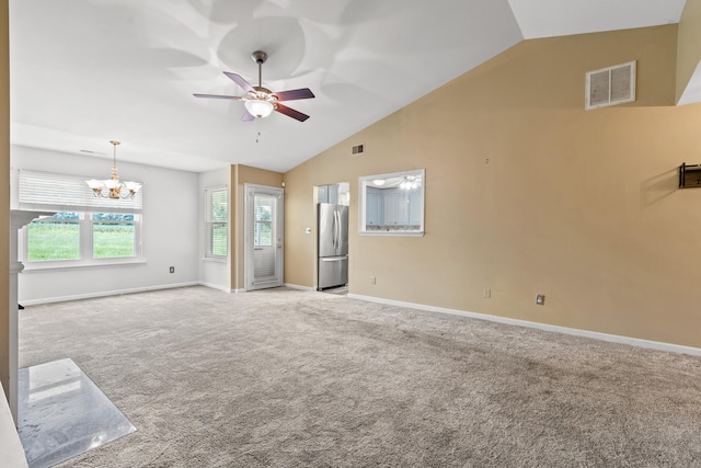 carpeted empty room with ceiling fan with notable chandelier and vaulted ceiling