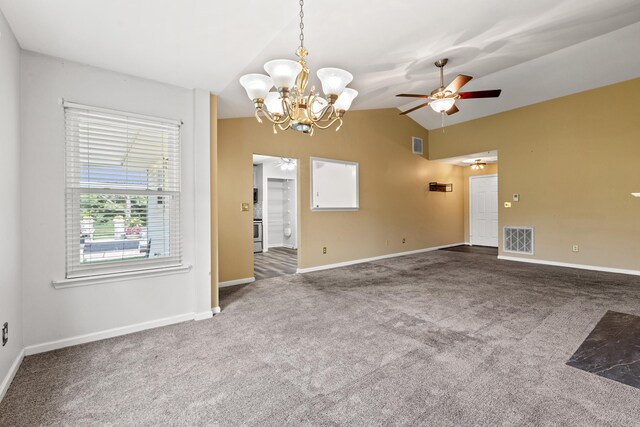 empty room featuring vaulted ceiling, carpet floors, and ceiling fan with notable chandelier