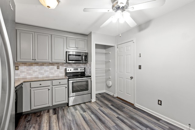 kitchen featuring backsplash, appliances with stainless steel finishes, dark hardwood / wood-style floors, gray cabinetry, and ceiling fan