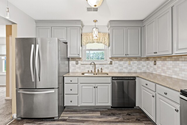 kitchen with backsplash, dishwasher, stainless steel refrigerator, sink, and dark colored carpet