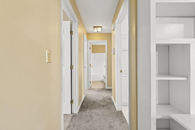 hall with light colored carpet