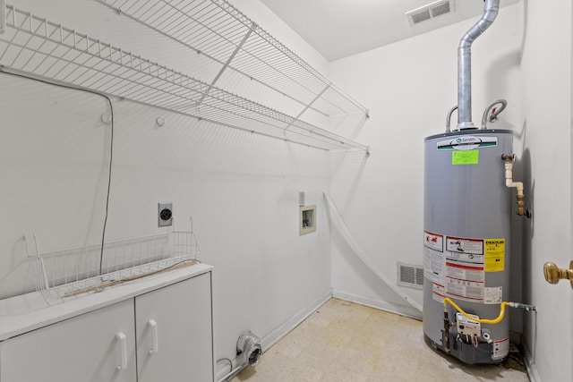 laundry area with gas water heater, cabinets, hookup for an electric dryer, hookup for a washing machine, and light tile patterned floors