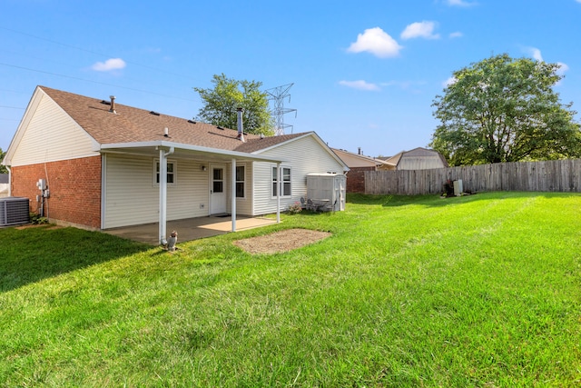 rear view of property with a patio area, a lawn, and cooling unit