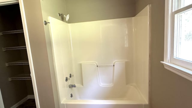 bathroom featuring a healthy amount of sunlight and washtub / shower combination