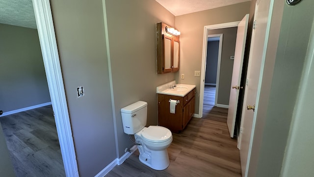 bathroom featuring hardwood / wood-style flooring, vanity, and toilet