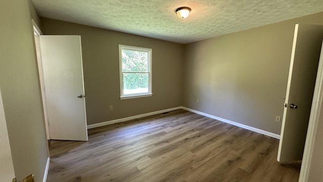 unfurnished bedroom with a textured ceiling and light hardwood / wood-style flooring