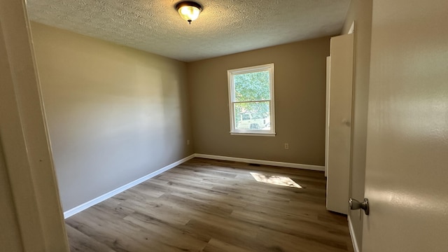 empty room featuring hardwood / wood-style floors and a textured ceiling