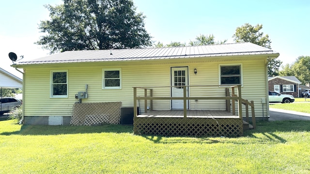 back of house featuring a wooden deck and a lawn