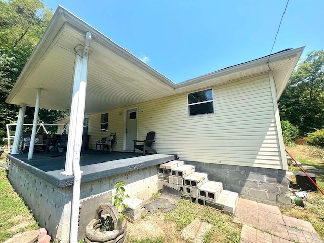 rear view of property featuring a porch and a carport