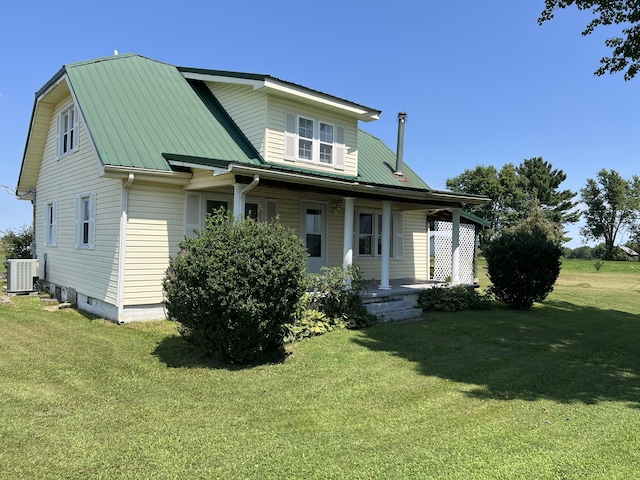 rear view of property featuring central AC and a lawn