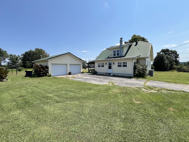 view of front of house with an outdoor structure, central AC unit, a front yard, and a garage